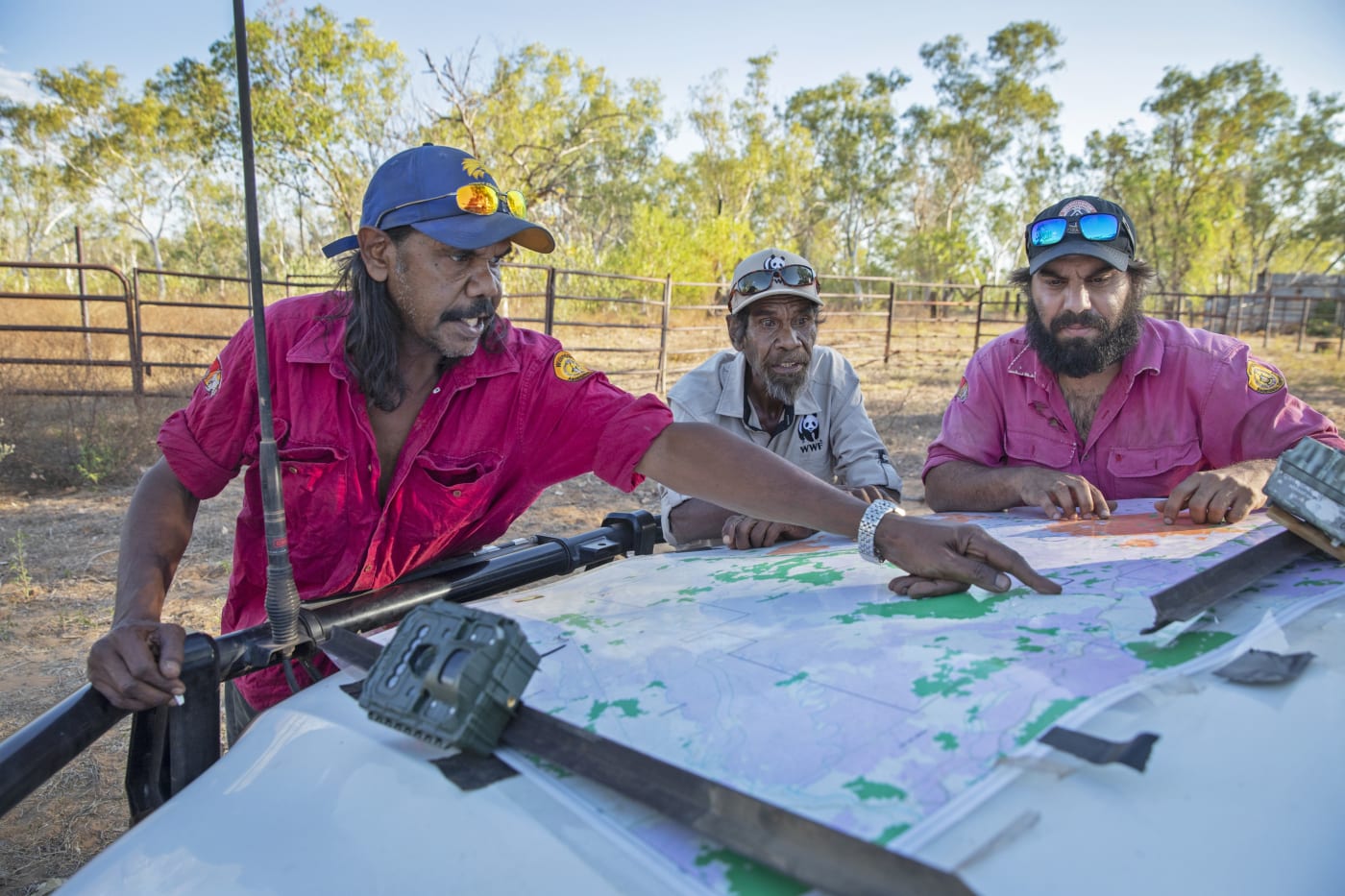 Nyaliga Ranger Thomas Birch points to a map location watched by WWF's Pius Gregory (middle) and Nyaliga Ranger Silas Purcell (right)