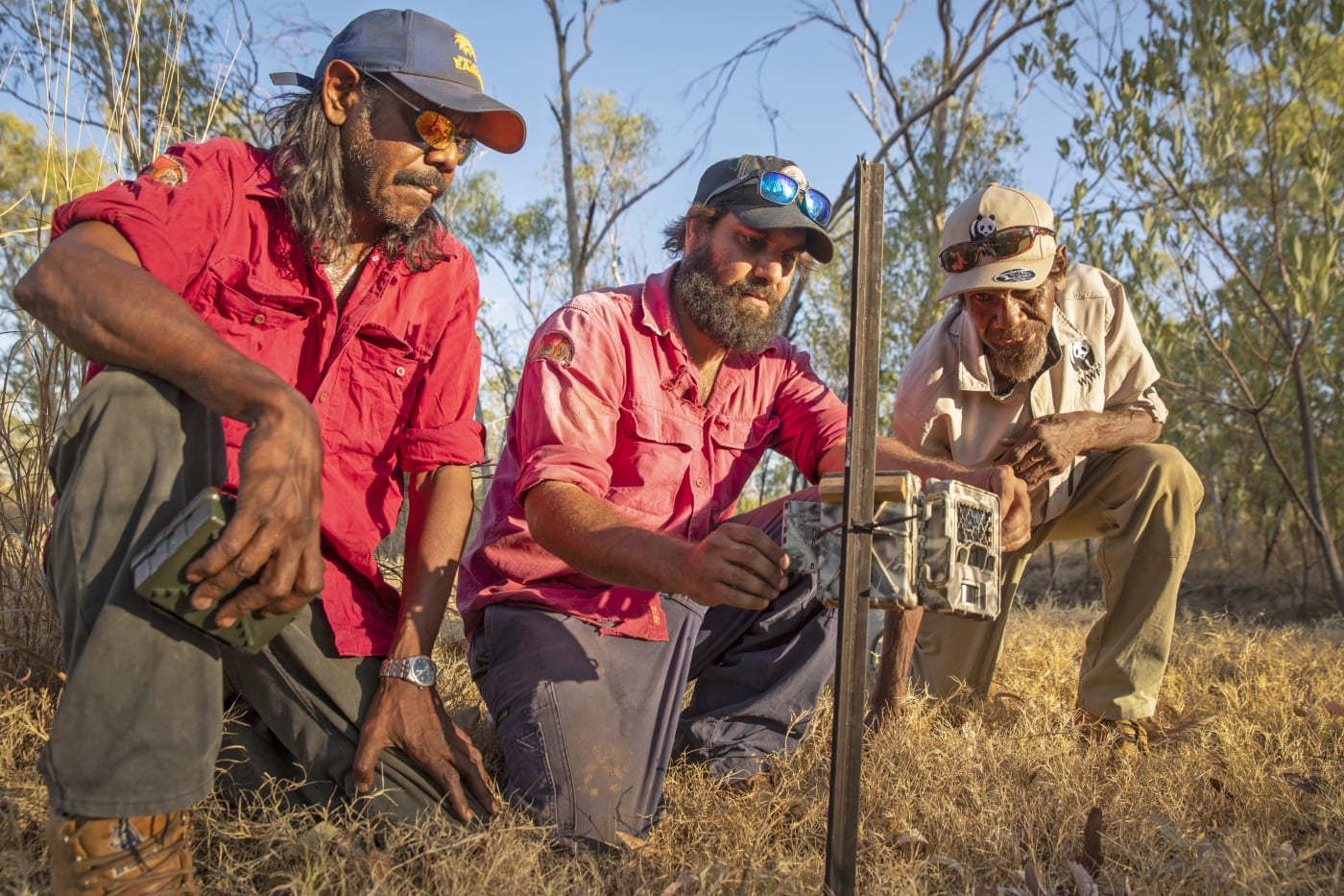 Nyaliga Rangers Thomas Birch (left) and Silas Purcell (middle) and WWF's Pius Gregory setting up a sensor camera.