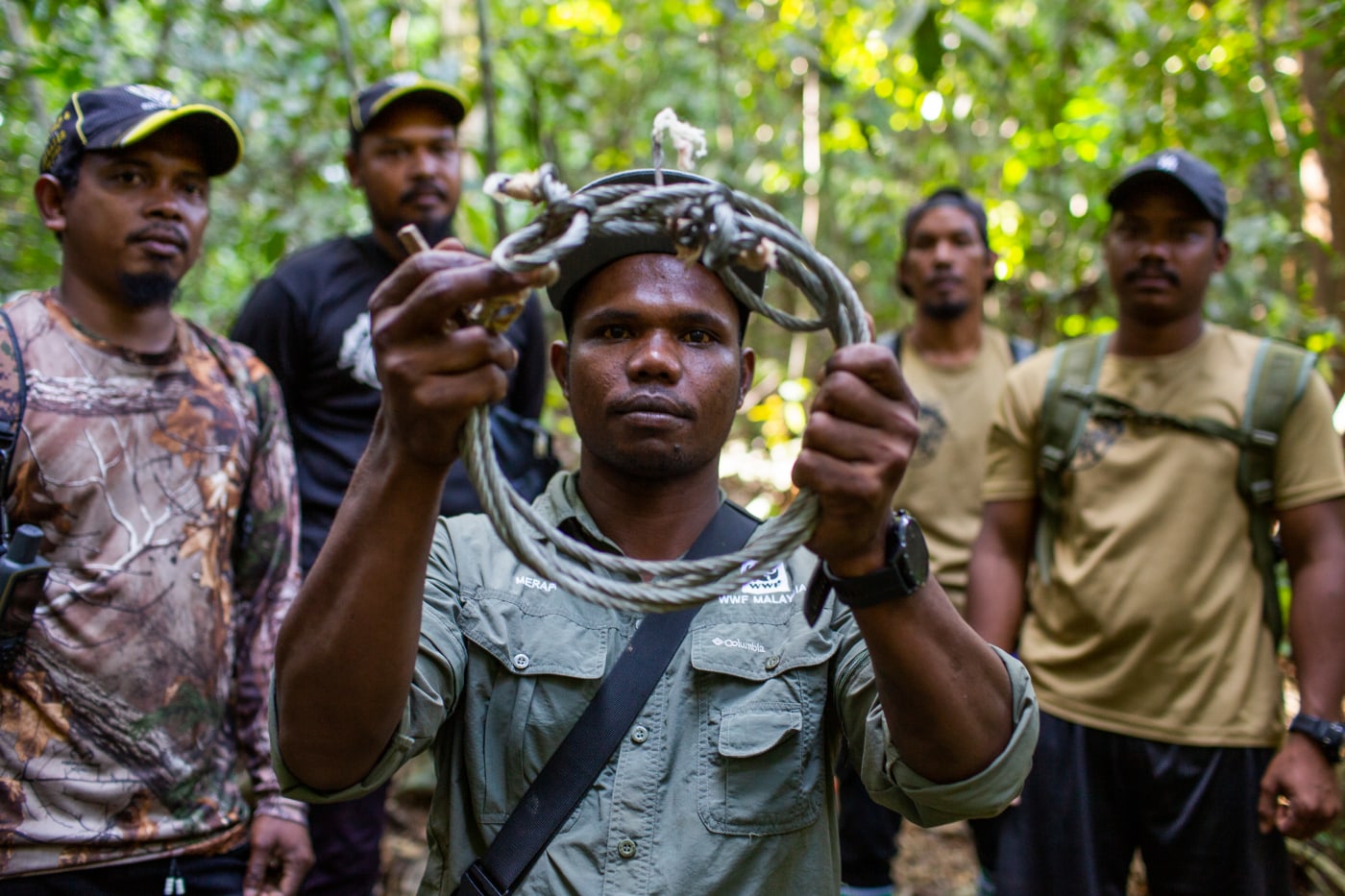 Merapi Mat Razi (centre) holds a snare that was removed from Royal Belum State Park, Malaysia.