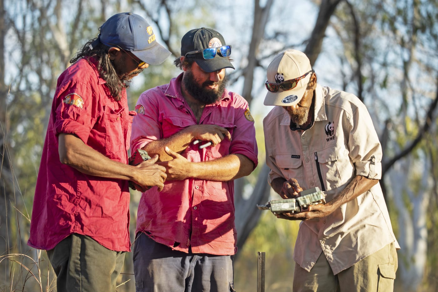 Nyaliga Rangers Thomas Birch (left) and Silas Purcell (middle) and WWF's Pius Gregory check a camera.