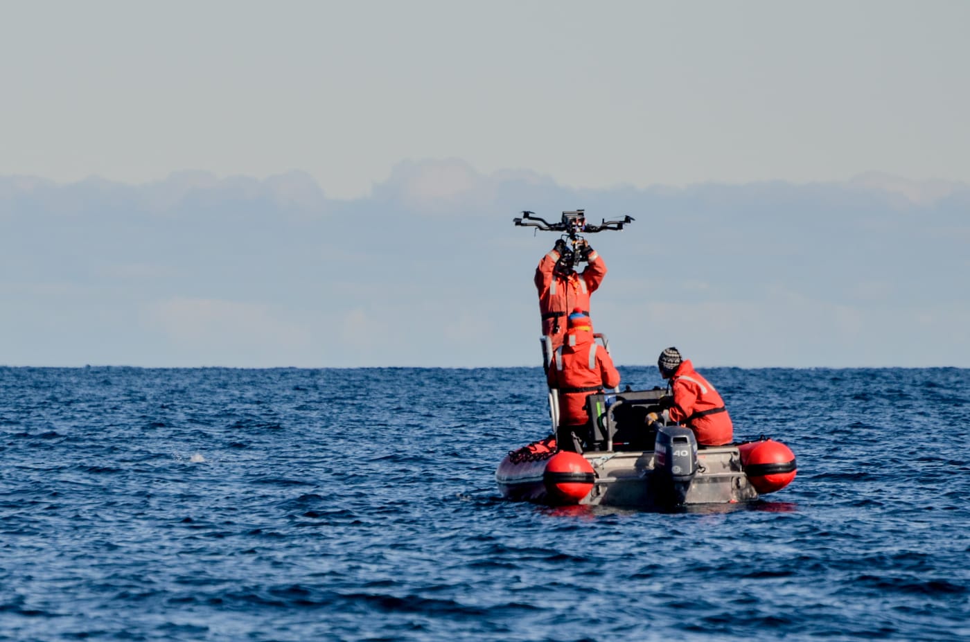 Researchers prepare to fly a drone over a humpback whale