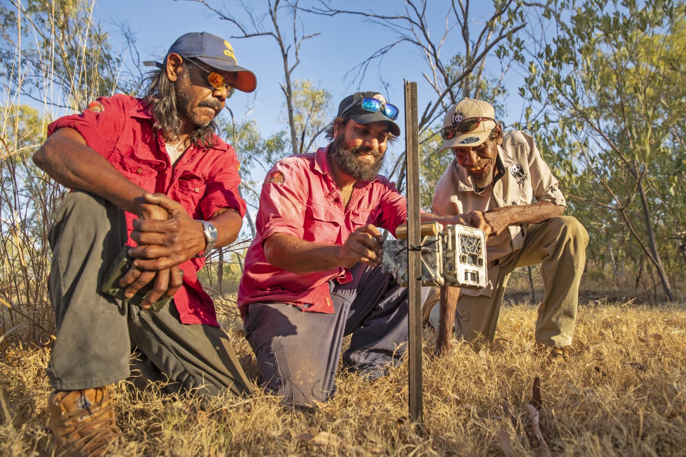 Nyaliga Rangers Thomas Birch (left) and Silas Purcell (middle) and WWF's Pius Gregory check a sensor camera.