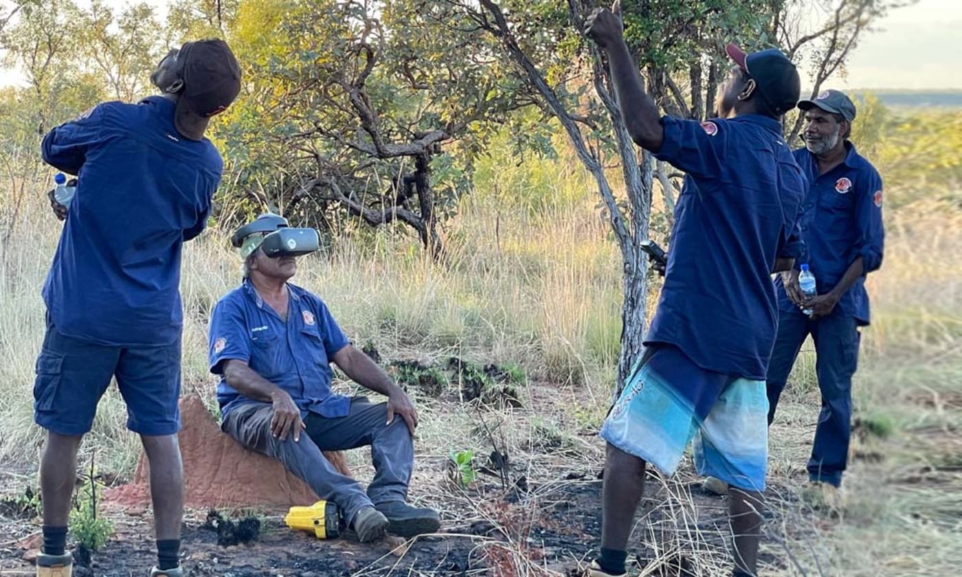 Nyikina Mangala Ranger Redman Charles using drone vision goggles to search for wiliji in caves on the Erskine Range while his Ranger team mates spot the drone overhead