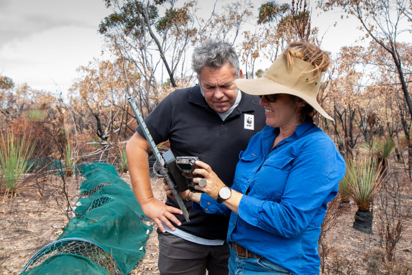 Darren Grover and Heidi Groffen check a sensor camera for signs of dunnarts on a fire-affected property