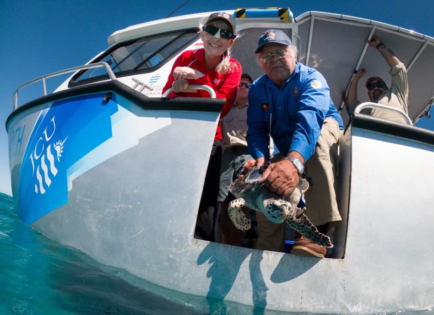 Birri Gubba Juru Elder and Gudjuda senior ranger Jim Gaston releasing hawksbill turtle at John Brewer Reef with James Cook University’s Turtle Health Research staff