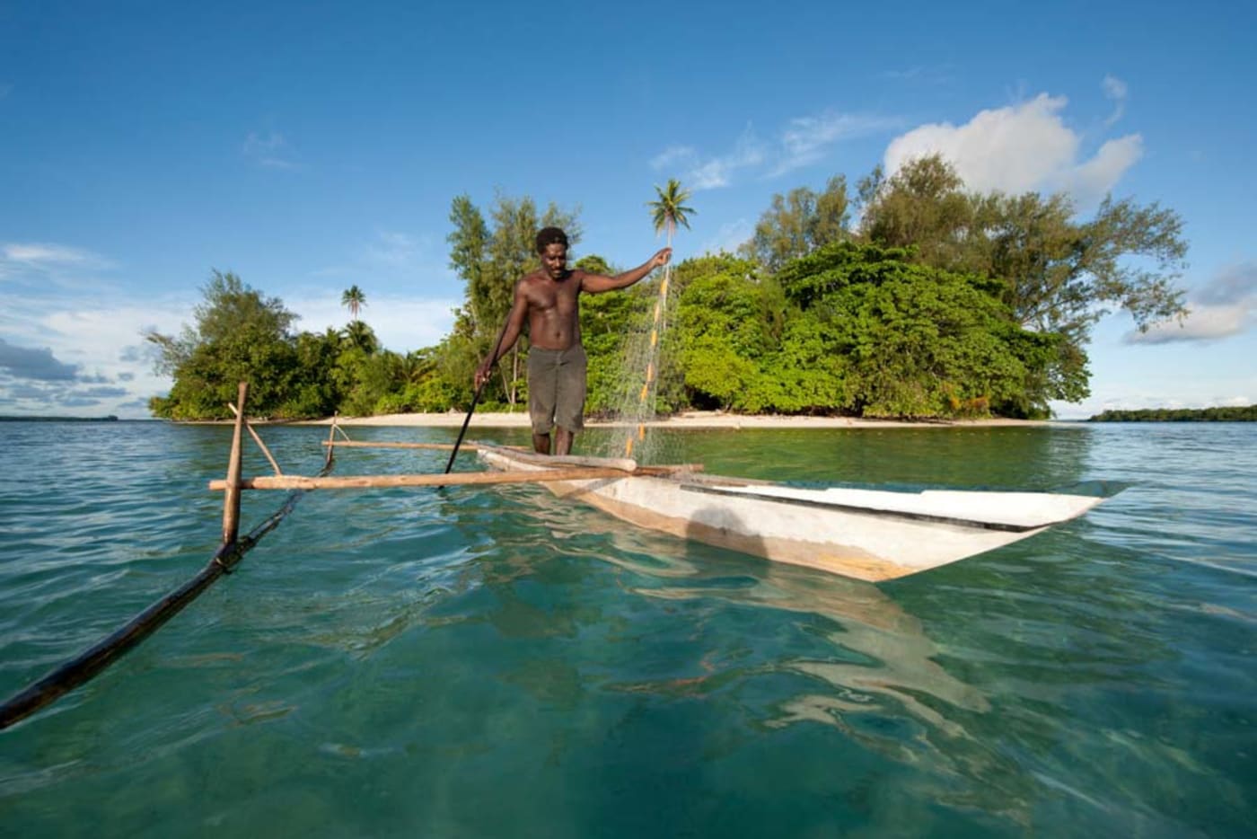 A Papua New Guinea islander paddles his dugout canoe to go fishing
