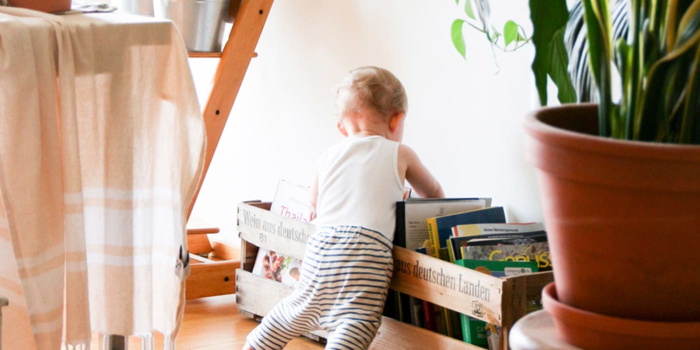Toddler rummaging through eco-friendly books. Photo by Brina Blum on Unsplash