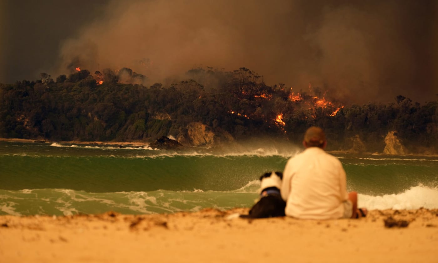 Man and dog on the beach during Malua Bay Bushfire NSW= Australia= January 2020