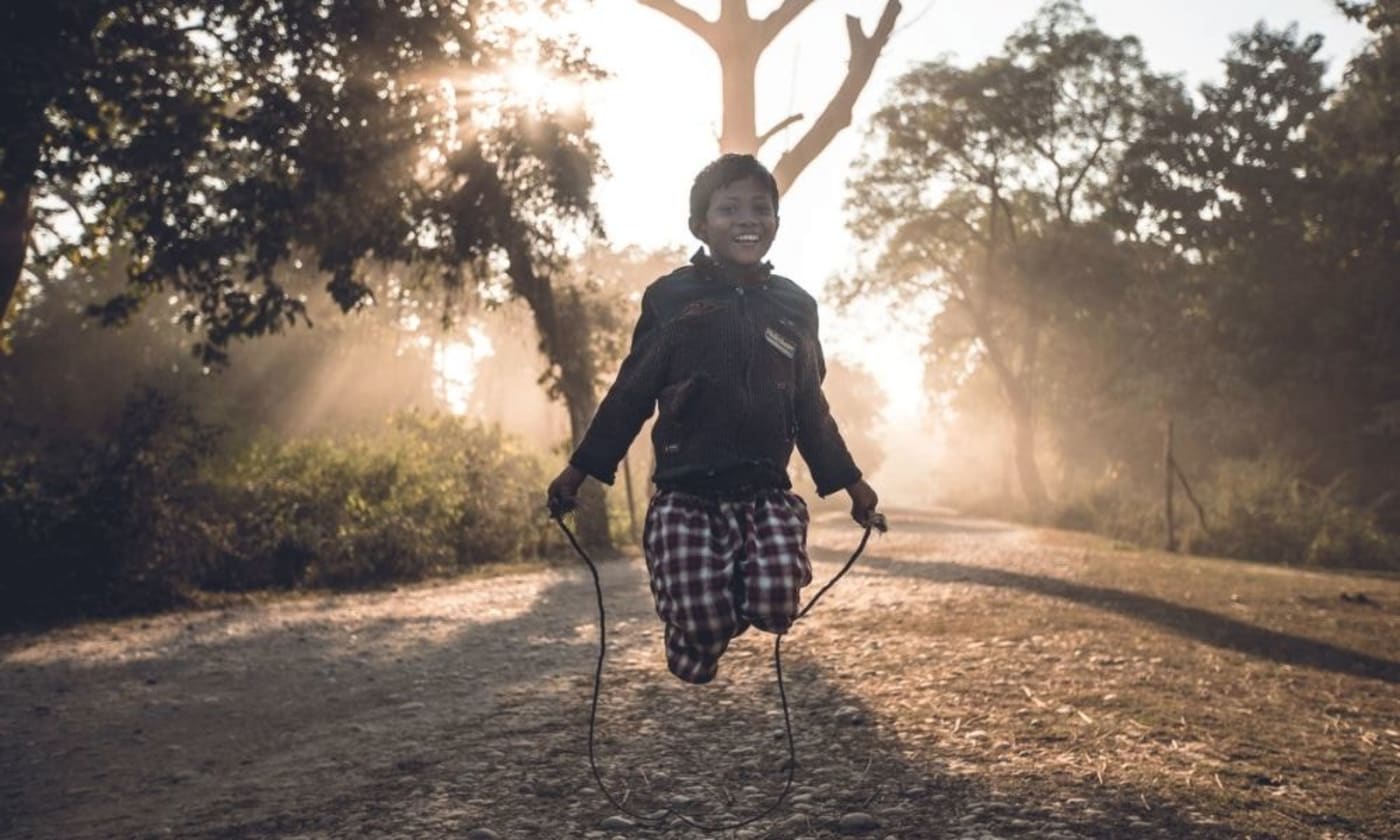 Boy skipping in forest