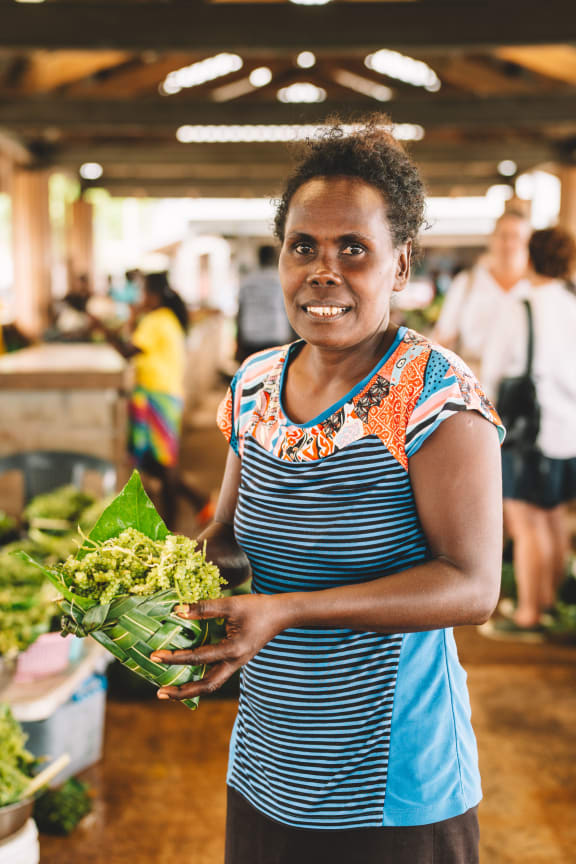 Nerolyn, a community facilitator, selling sea grapes at the local market.