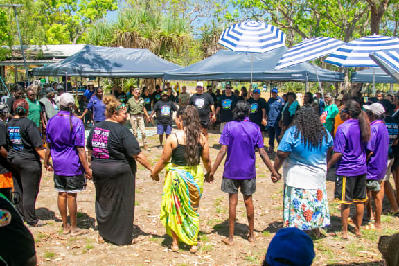 Arrernte woman from Mparntwe (Alice Springs) and Central Land Council member Jody Kopp and her daughter, NT Youth Round Table member and young Arrernte leader Armani Francois join hands with other Message Stick members at the 2023 Strong Women for Healthy Country Forum.