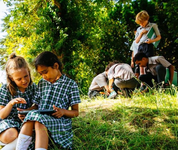 School children sitting outside