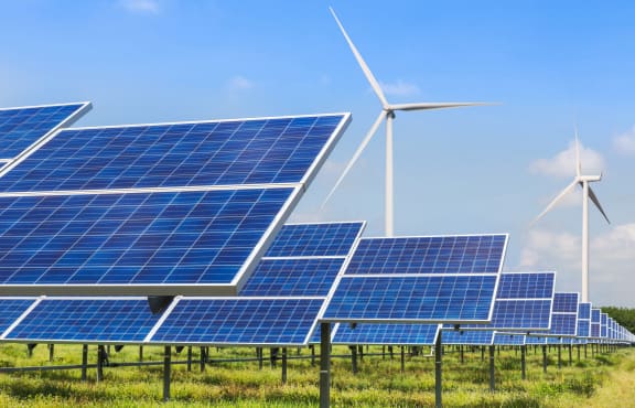 Solar panels and wind turbines generating electricity in solar power station