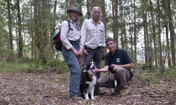 Lynn Baker and Brad Nesbitt from Canines for Wildlife (standing), Dr Stuart Blanch (kneeling) beside detection dog Fen.