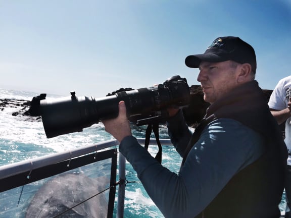 Bequestor and photographer Chris Farrell photographing a pod of dolphins. Seal Rocks, Victoria.