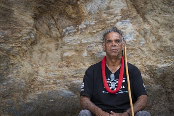 Gumbaynggirr Elder and educator Uncle Micklo Jarrett sitting at Valla Beach, Gumbaynggirr Country
